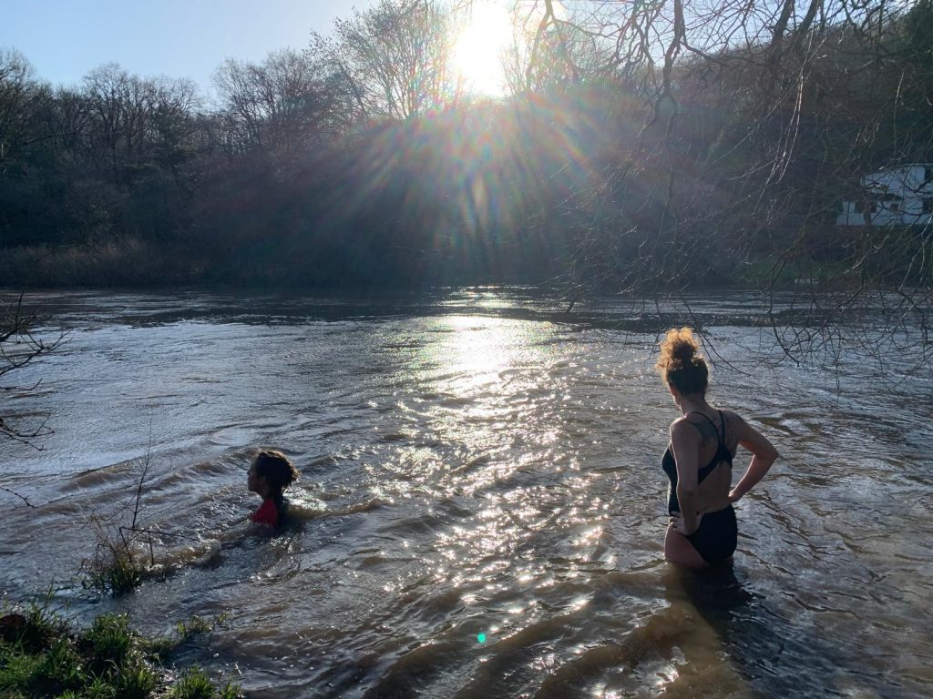 Two swimmers in the River Avon. The sun is shining.